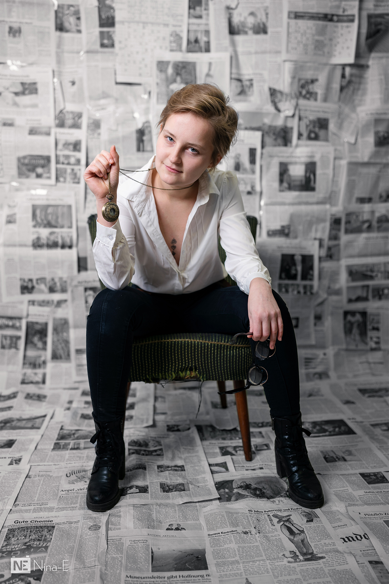 Person sitz auf Stuhl und zeigt Taschenuhr