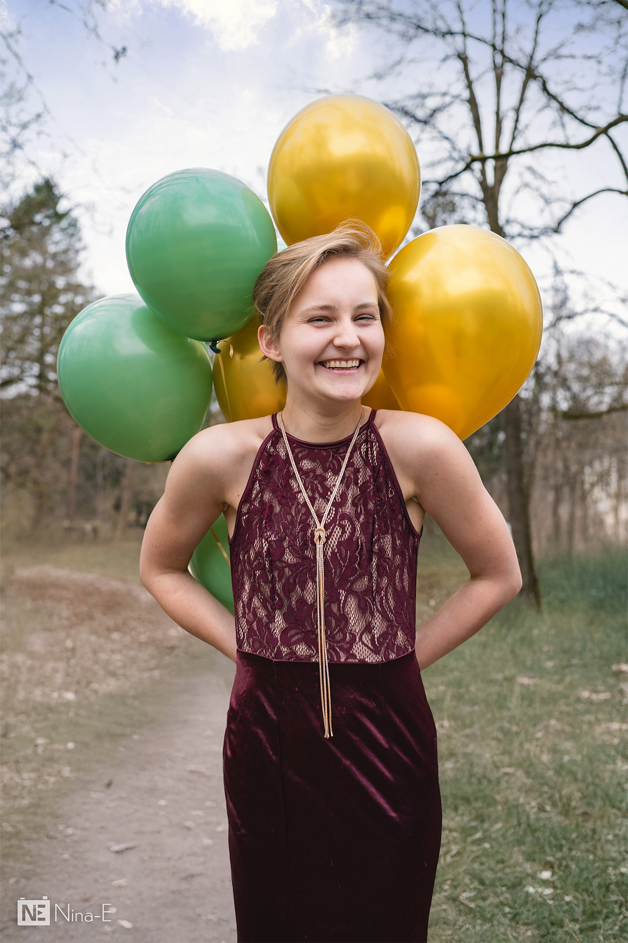 Person versteckt Strauß aus Luftballons hinterm Rücken